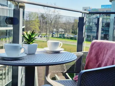 two cups and saucers on a table on a balcony at MELODIJA apartments in Druskininkai center in Druskininkai