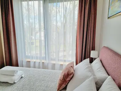 a bedroom with a bed with a large window at MELODIJA apartments in Druskininkai center in Druskininkai