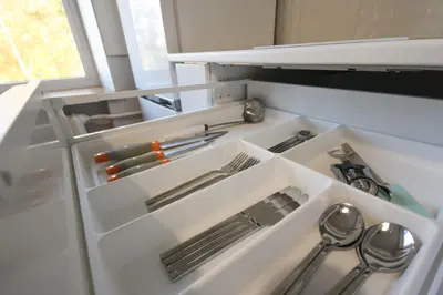 an open refrigerator with silver utensils in it at Sonatina apartment in Druskininkai