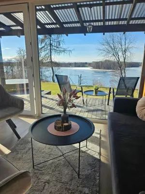 a living room with a table and a view of the water at Volunge house in Doškonys