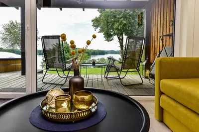 a table with a vase and some gold cups on it at Volunge house in Doškonys