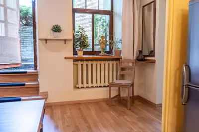 a room with a radiator and a chair and a window at Cozy Suite with Inner Yard in Vilnius