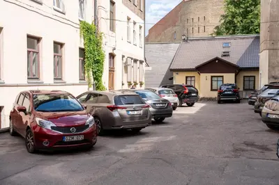 a row of cars parked on the side of a street at Cozy Suite with Inner Yard in Vilnius
