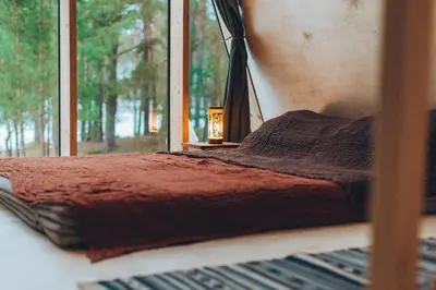 a bed in a room with a window at Trikampis MIŠKO NAMELIS Druskininkų centre in Druskininkai