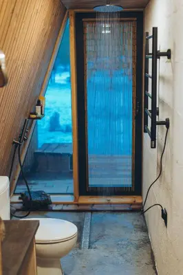a bathroom with a toilet in front of a window at Trikampis MIŠKO NAMELIS Druskininkų centre in Druskininkai