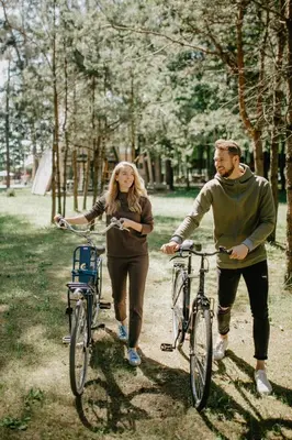 a man and a woman walking their bikes at Trikampis MIŠKO NAMELIS Druskininkų centre in Druskininkai