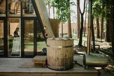a wooden barrel sitting on a wooden deck with a staircase at Trikampis MIŠKO NAMELIS Druskininkų centre in Druskininkai