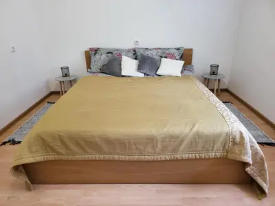 a bedroom with a large bed with two tables at Alka Lake Inn in Druskininkai