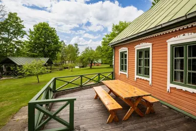 a wooden deck with a picnic table on a house at Alaušo Salos - Malinauskų kaimo turizmo sodyba in Sudeikiai