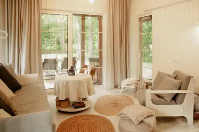 a living room with a table and chairs at ALNUS KIEMAS in Kampiškiai