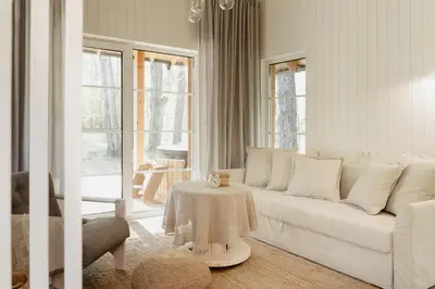 a living room with a white couch and a table at ALNUS KIEMAS in Kampiškiai
