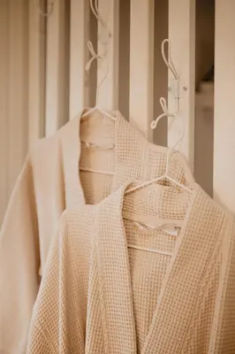 a white robe is hanging on a rack at ALNUS KIEMAS in Kampiškiai