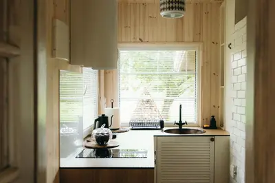 a kitchen with two sinks and a window at ALNUS KIEMAS in Kampiškiai