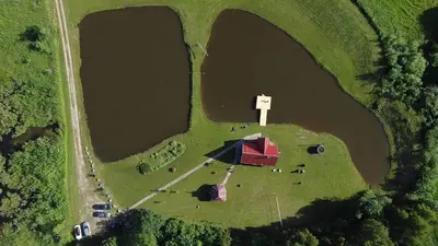 an aerial view of a farm with a barn and a lake at Sodyba Anykščių raj. in Anykščiai