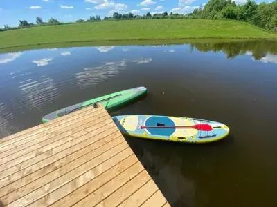 two boats are sitting on the water next to a dock at Sodyba Anykščių raj. in Anykščiai