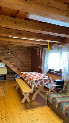 a room with a table and a bench in a cabin at Saulėtekio 12 in Ignalina