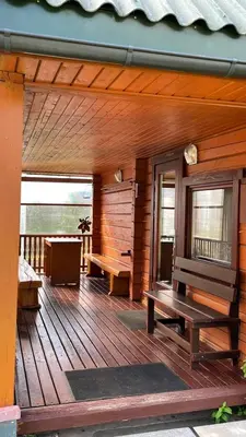 a porch of a wooden cabin with benches on it at Saulėtekio 12 in Ignalina
