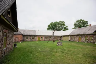 a courtyard of an old stone building with a tree at Rest Green in Degesiai
