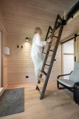 a man climbing a ladder in a room at Rest Green in Degesiai