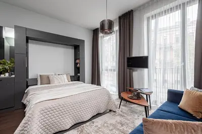 a bedroom with a large bed and a blue couch at Vilnius Old Town Renaissance Studio 2 in Vilnius