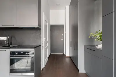 a kitchen with white cabinets and a black counter top at Vilnius Old Town Renaissance Studio 2 in Vilnius