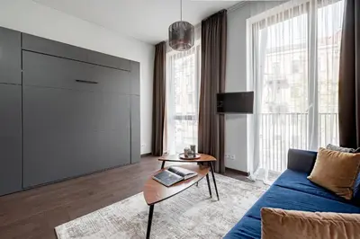 a living room with a blue couch and a table at Vilnius Old Town Renaissance Studio 2 in Vilnius