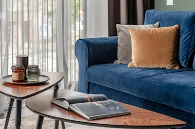 a living room with a blue couch and a table at Vilnius Old Town Renaissance Studio 2 in Vilnius
