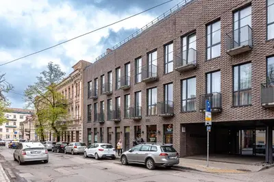 a large brick building with cars parked on a street at Vilnius Old Town Renaissance Studio 2 in Vilnius