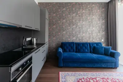 a living room with a blue couch in a kitchen at Vilnius Old Town Renessainse Studio 3 in Vilnius