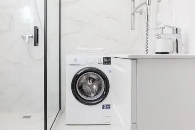 a washing machine in a bathroom next to a sink at Vilnius Old Town Renessainse Studio 3 in Vilnius