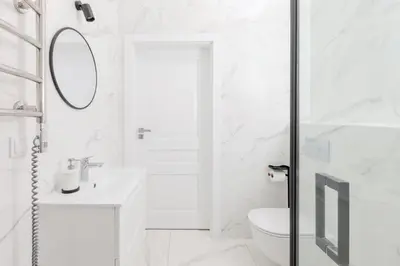 a white bathroom with a toilet and a sink at Vilnius Old Town Renessainse Studio 3 in Vilnius