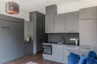 a kitchen with white cabinets and blue appliances at Vilnius Old Town Renessainse Studio 3 in Vilnius