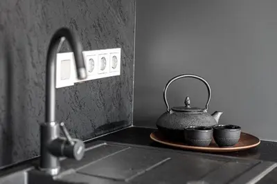 a tea kettle and two cups on a plate on a kitchen counter at Vilnius Old Town Renessainse Studio 4 in Vilnius