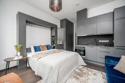 a bedroom with a bed and a table and a kitchen at Vilnius Old Town Renessainse Studio 4 in Vilnius