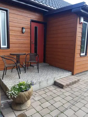 a patio with a table and chairs and a red door at LIUX apartamentai in Kaunas