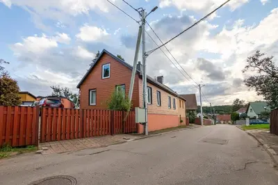 a house with a red fence and a house at LIUX apartamentai in Kaunas