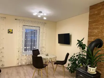 a dining room with a table and chairs and a television at LIUX apartamentai in Kaunas