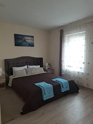 a bedroom with a large bed with two towels on it at LIUX apartamentai in Kaunas
