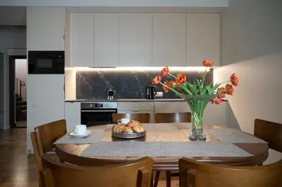 a kitchen with a table with a vase of flowers at Villa ACACIA in Kaunas