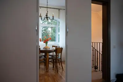 a dining room with a table and a chandelier at Villa ACACIA in Kaunas