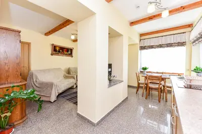 a kitchen and living room with a table and chairs at Žemyna Apartmentai in Druskininkai