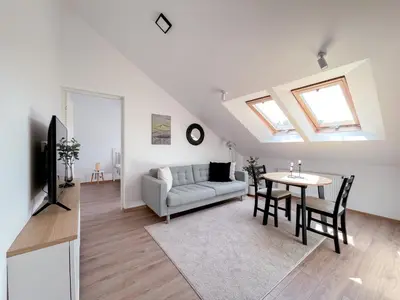 a living room with a couch and a table at Upės apartamentai in Birštonas
