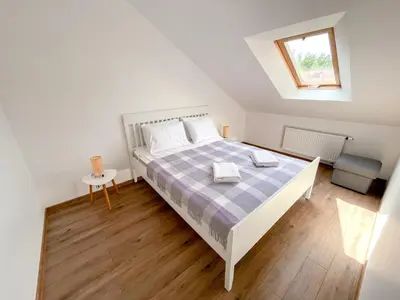 a bedroom with a bed with a blue and white bedspread at Upės apartamentai in Birštonas