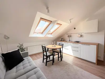 a living room with a couch and a table at Upės apartamentai in Birštonas