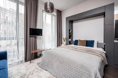 a bedroom with a large bed and a large window at Vilnius Old Town Studio Renessaince 5 in Vilnius