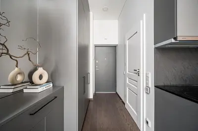 a kitchen with white cabinets and a hallway at Vilnius Old Town Studio Renessaince 5 in Vilnius