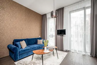 a living room with a blue couch and a table at Vilnius Old Town Studio Renessaince 5 in Vilnius