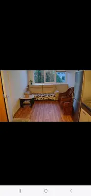 a living room with a couch and two windows at Ežero 8-90 in Šiauliai
