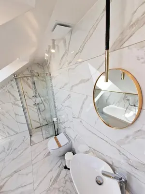 a white bathroom with a sink and a mirror at Editos apartamentai in Jurbarkas