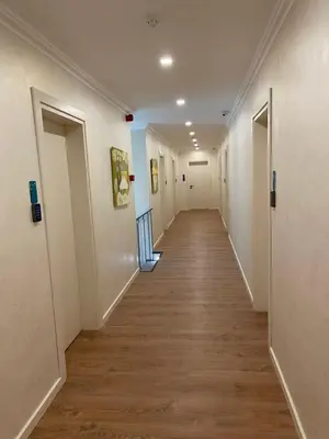 a long hallway with white walls and wooden floors at Editos apartamentai in Jurbarkas
